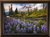 Framed artwork of a mountain landscape with purple flowers and trees by Ryan Smith